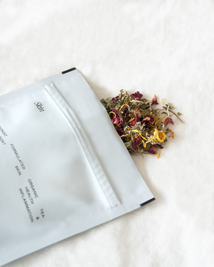Skin tea pouch opened with tea herbs pouring out 